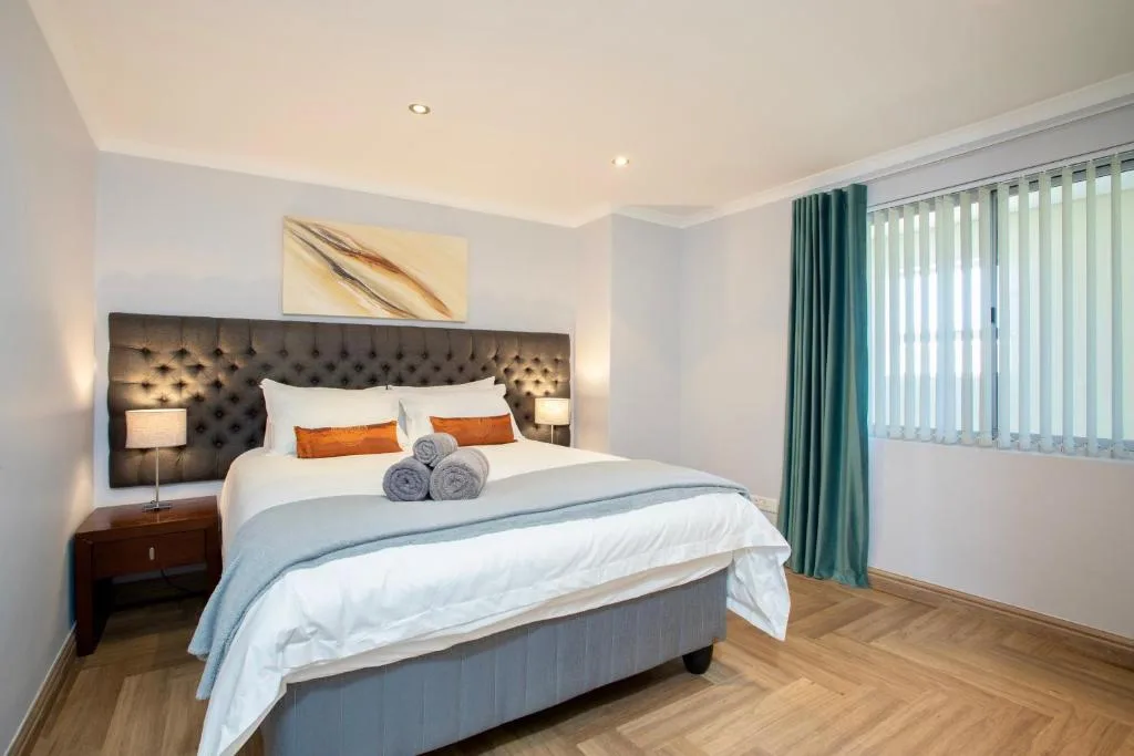 Spacious bedroom with king bed, tufted headboard, and modern amenities
