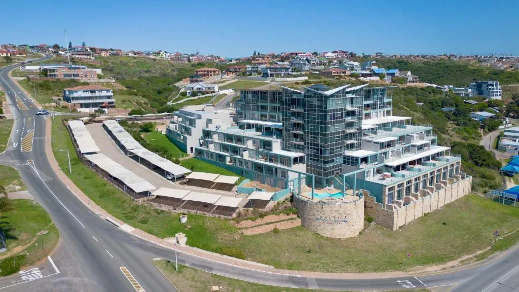Modern multi-story beachfront apartment building with curved architecture and ocean views