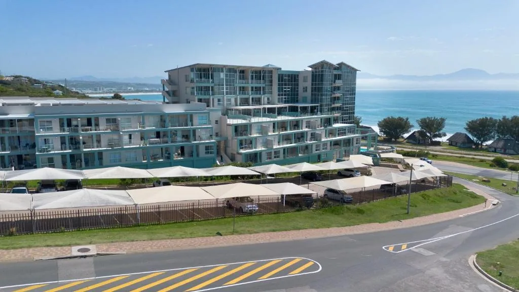 Modern beachfront apartment building with ocean views and sandy coastline