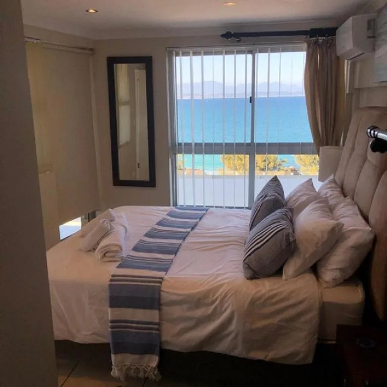 Bedroom with ocean view through sliding glass doors and balcony access