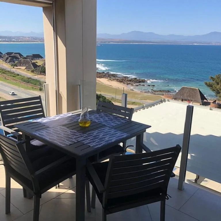Oceanview deck with dining table overlooking Mossel Bay coastline