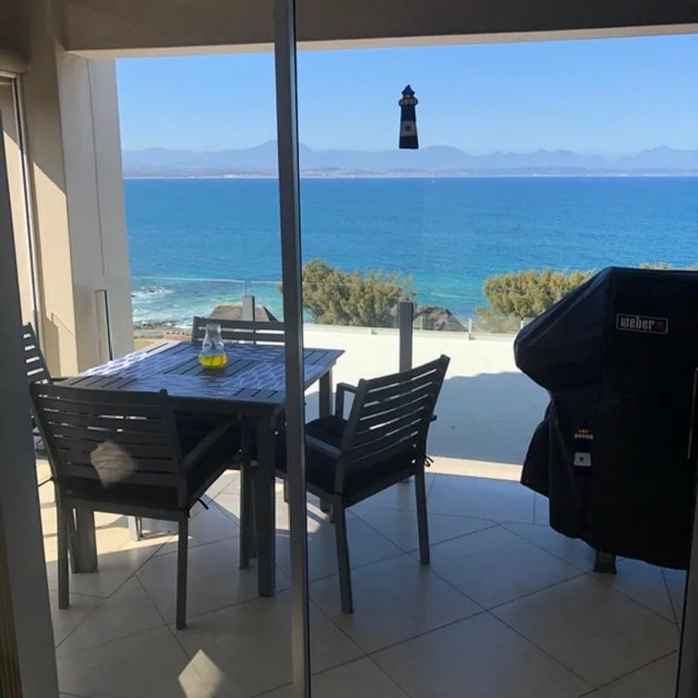 Outdoor deck with dining table and braai, ocean and lighthouse view