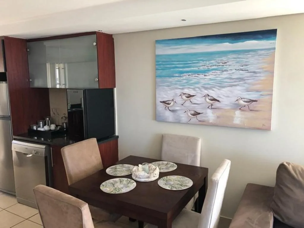 Dining table set with plates and artwork featuring coastal birds on wall