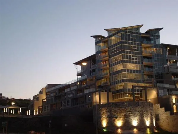 Modern multi-story waterfront apartment building illuminated at dusk