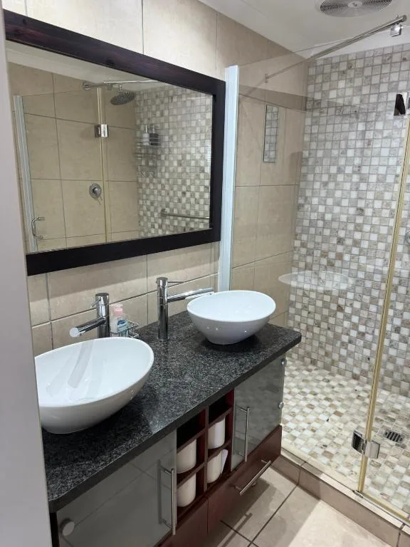 Modern bathroom with dual white vessel sinks and large mirror