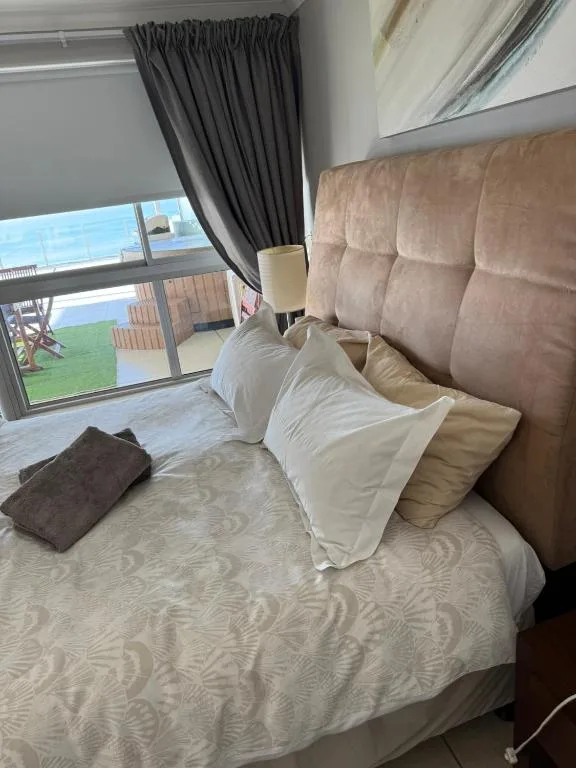 Spacious bedroom with ocean view, upholstered headboard, white pillows