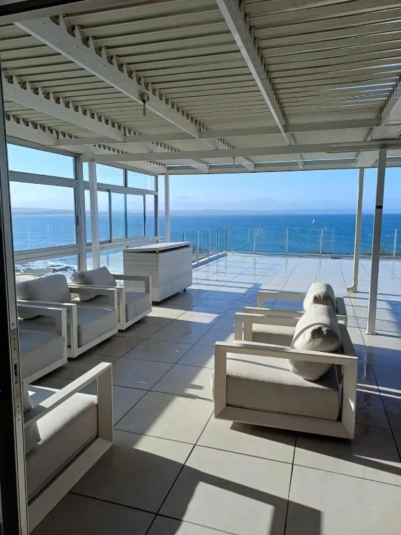 Covered oceanfront deck with lounge chairs and expansive sea views