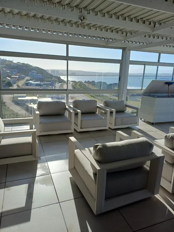 Contemporary deck with seating overlooking coastal town and ocean view