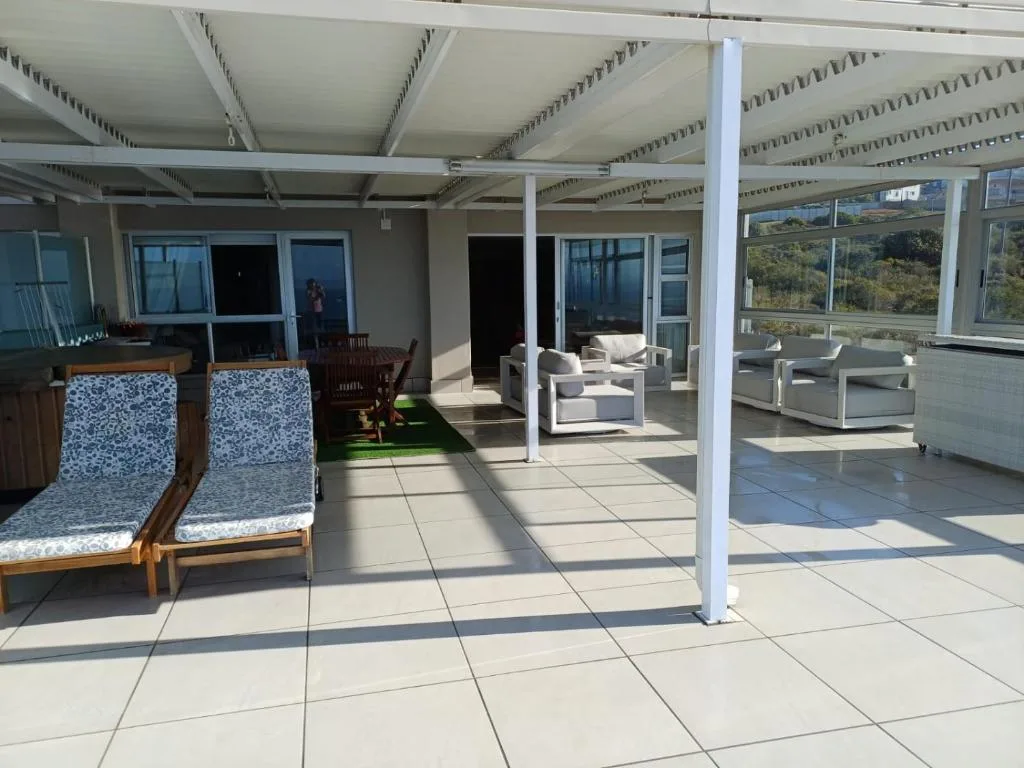 Spacious covered patio with lounge chairs and mountain views
