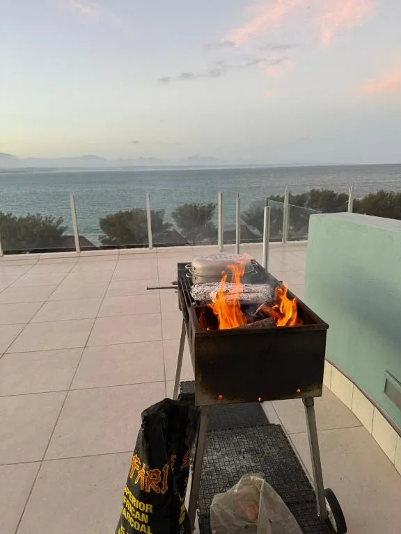 Braai fire burning on oceanfront deck with sea view