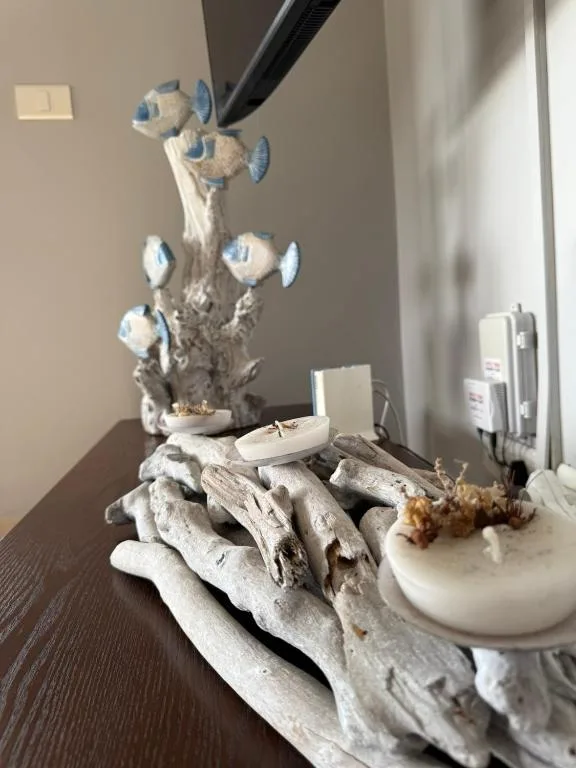 Decorative driftwood sculpture with blue fish figurines on bedroom shelf