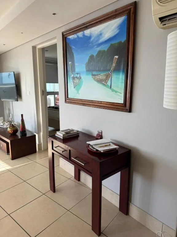 Modern lounge with wooden console table and tropical framed artwork