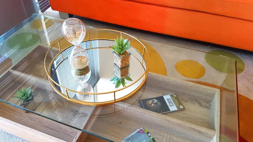Decorative gold tray with succulent plant and glass orbs on wooden shelf