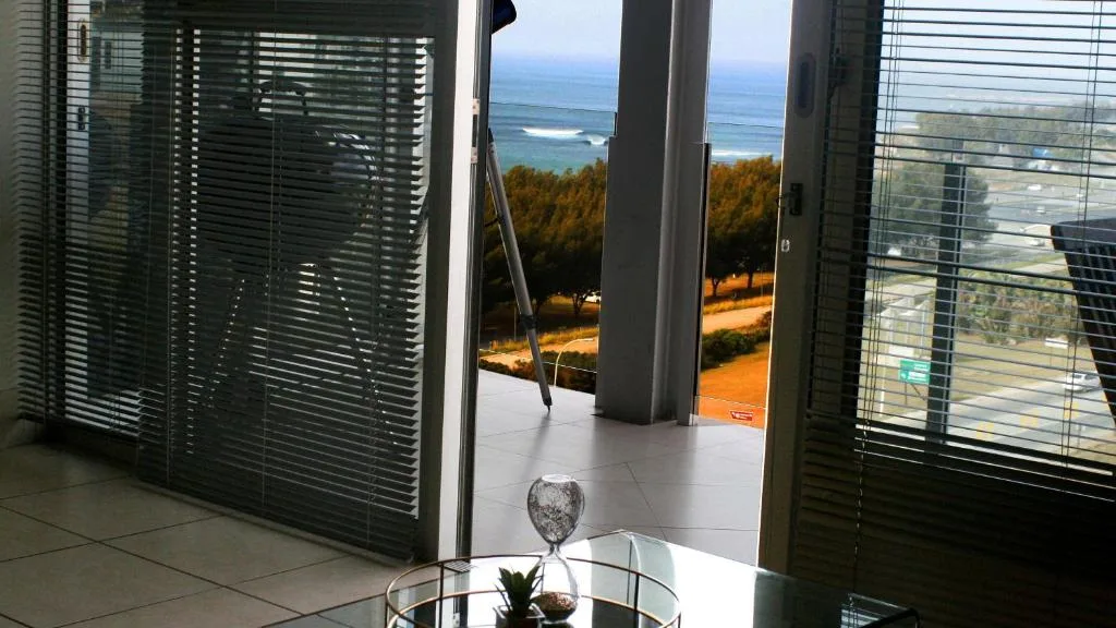 Ocean and coastline vista through open glass doors from indoors