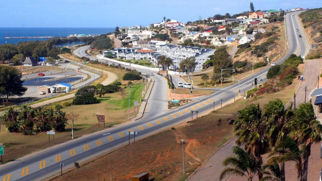 Coastal town hillside with ocean, roads, and residential buildings visible