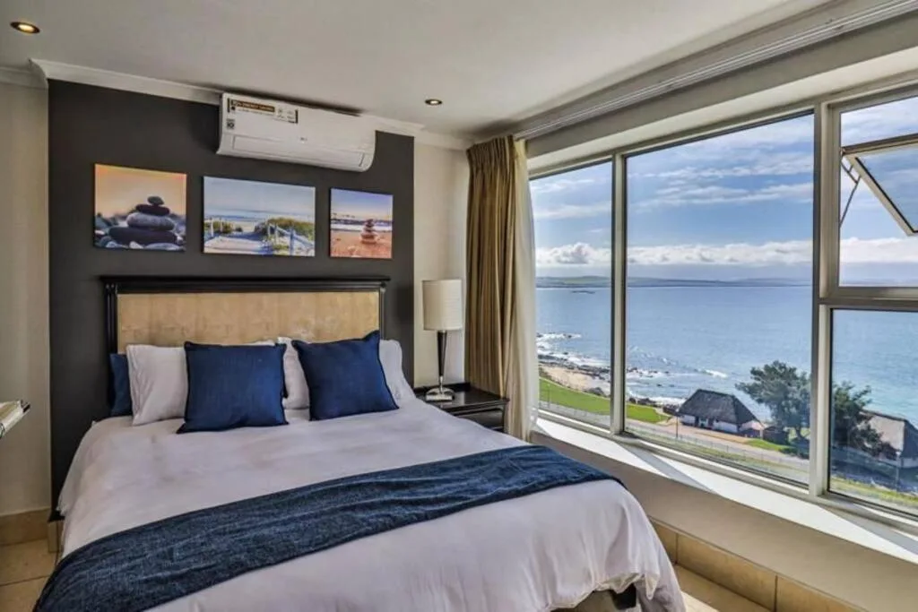 Bedroom with ocean and coastal view through large windows
