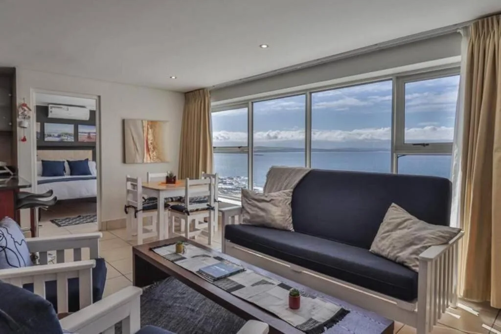 Modern lounge with black sofa and ocean view through large windows