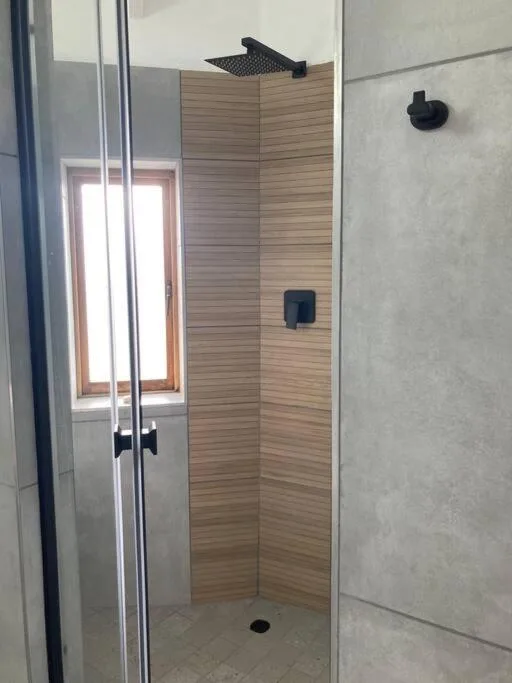 Modern walk-in shower with wood-effect tiling and rainfall showerhead