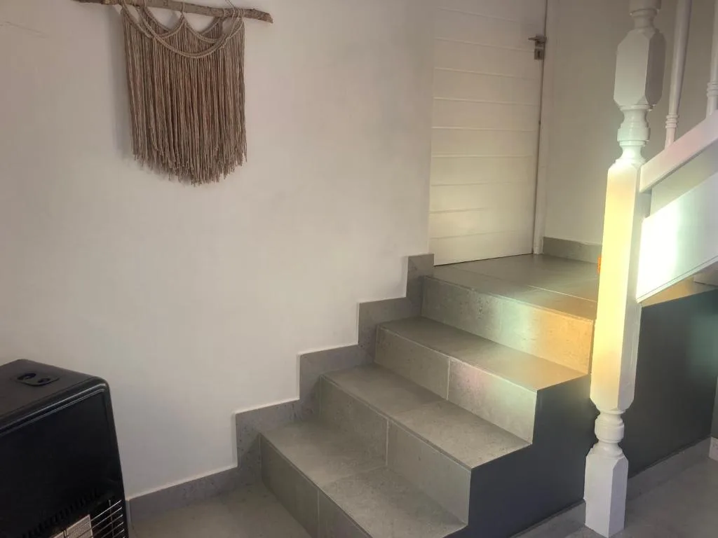 Interior staircase with white banister and macramé wall decoration