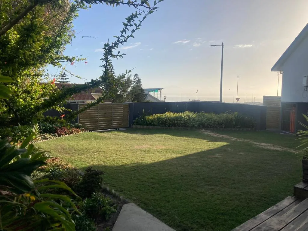 Spacious backyard garden with green lawn and established landscaping plants