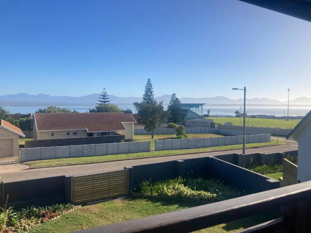 Scenic coastal view with mountains, lagoon, and neighboring properties visible