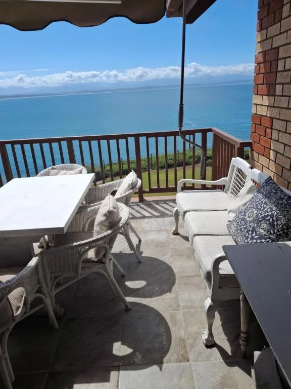 Oceanview deck with loungers, table, and panoramic sea horizon