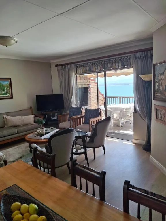 Spacious lounge with ocean view through sliding glass doors and balcony