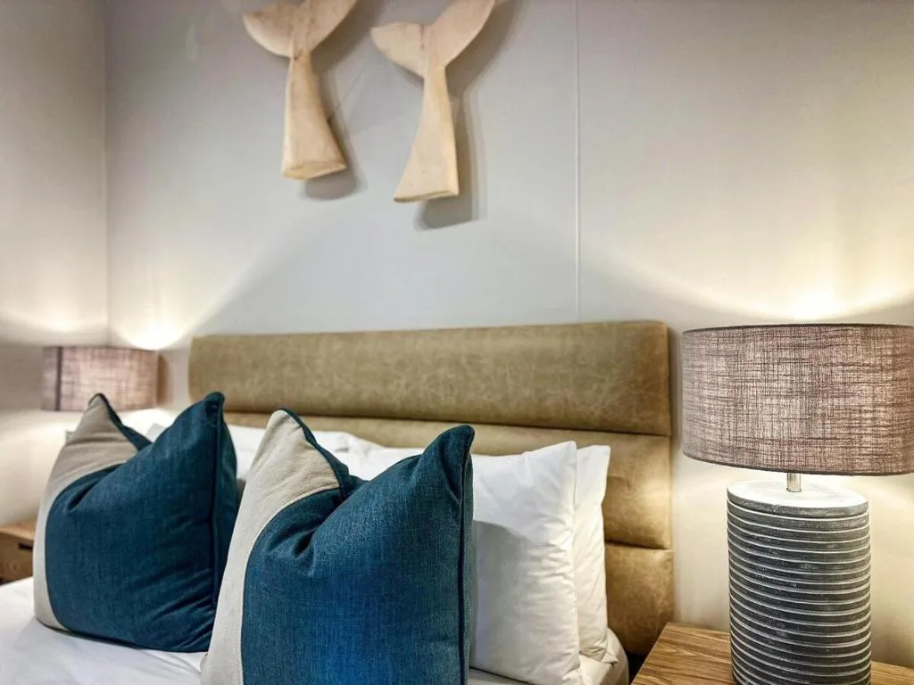 Modern bedroom with olive upholstered headboard, blue and white pillows