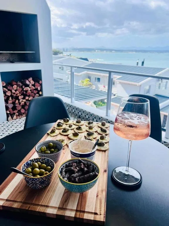 Outdoor terrace with appetizers, wine, and panoramic ocean views