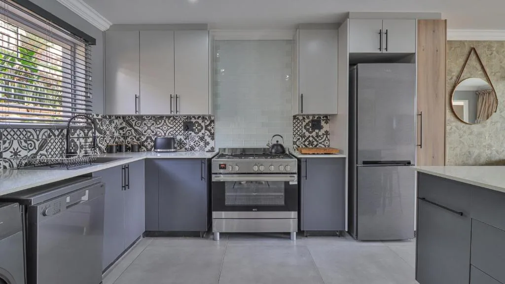 Modern kitchen with stainless steel appliances and patterned backtile