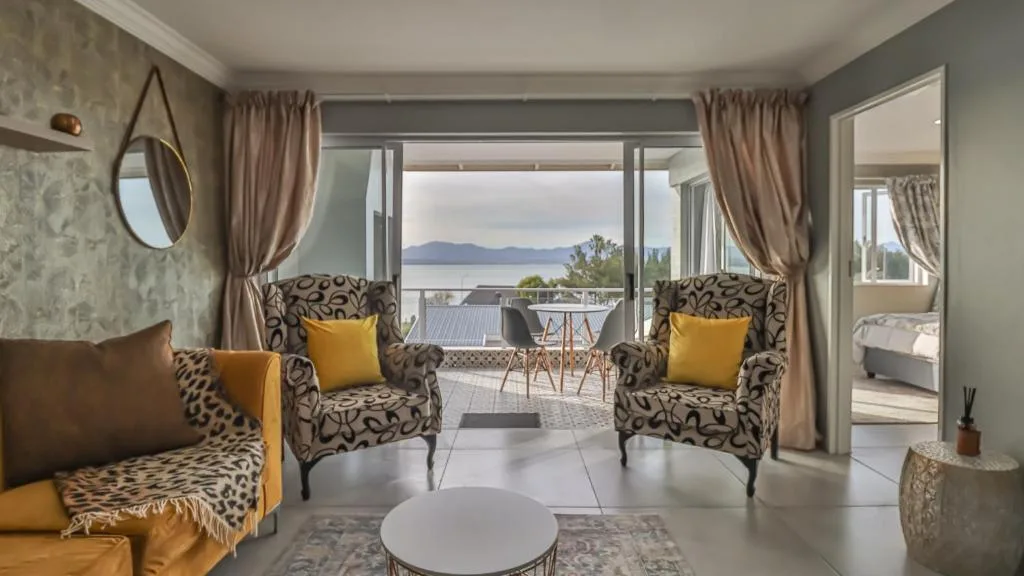 Modern lounge with patterned armchairs, ocean view through large windows