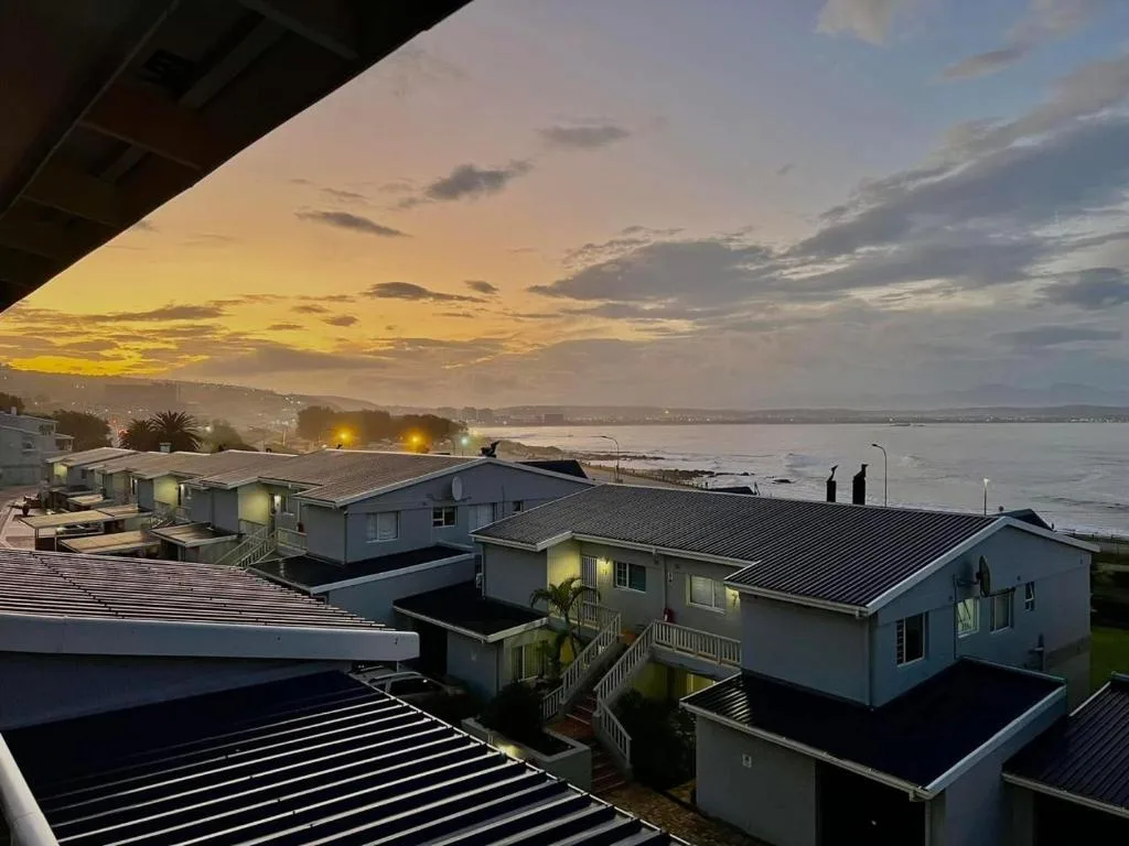 Sunset over Mossel Bay lagoon with waterfront properties and golden sky