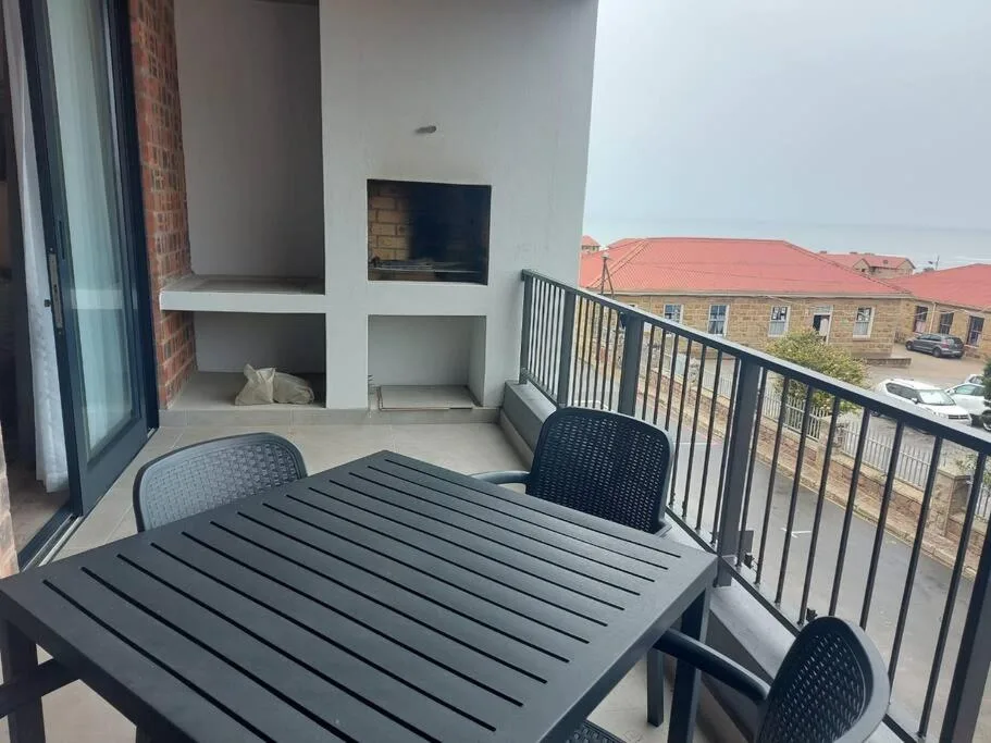 Outdoor balcony with dining table and chairs overlooking town