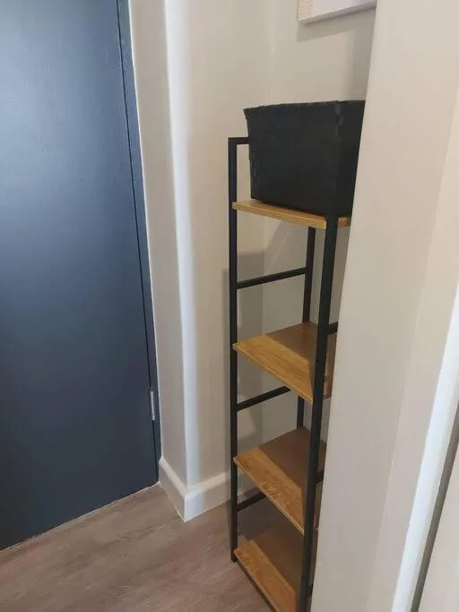 Tall wooden and black metal shelving unit in modern interior space