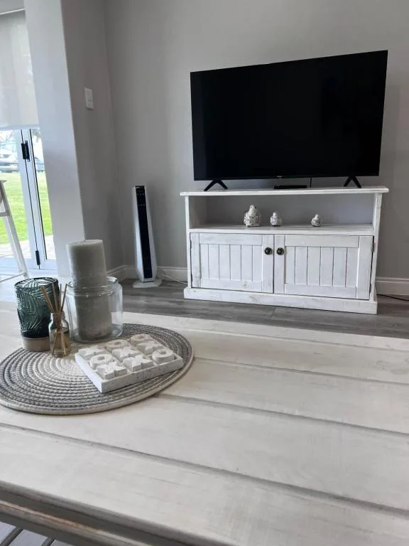 Modern living room with flat-screen TV mounted above white media cabinet