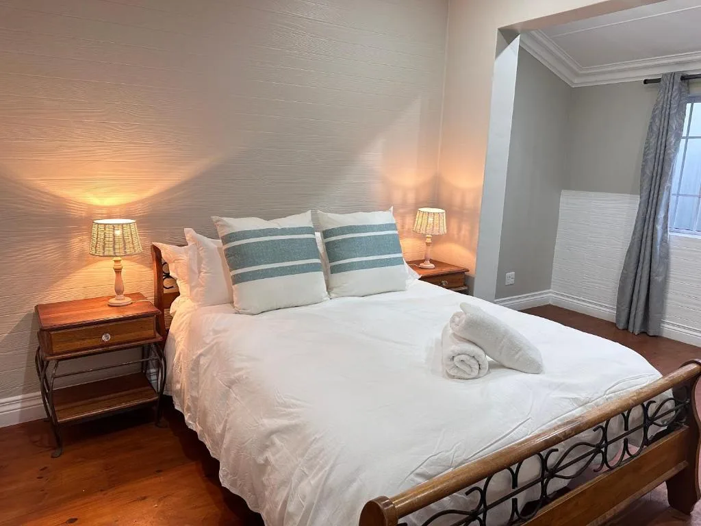 Elegant bedroom with queen bed, striped pillows, and warm lighting