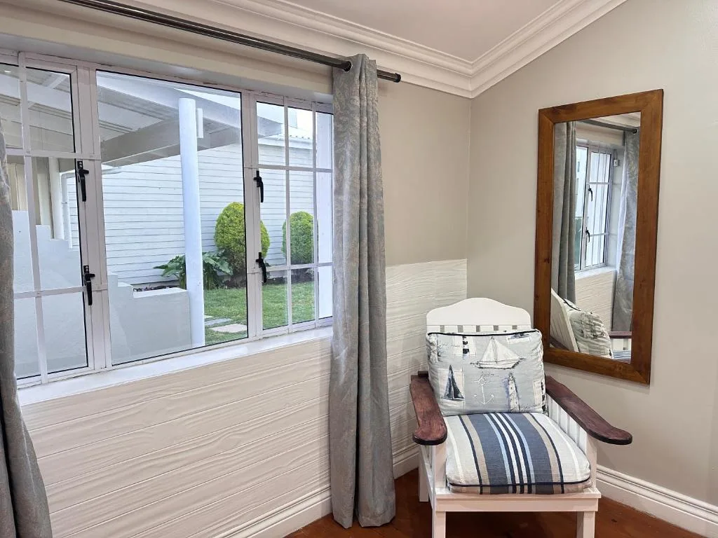 Bright bedroom with cot and garden view through large windows