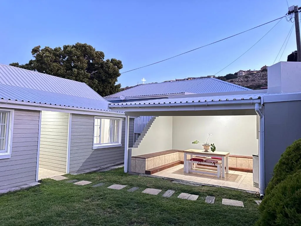 Covered outdoor patio with built-in bench seating and braai area