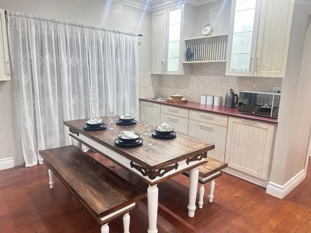 Elegant dining table with bench seating in modern kitchen with cream cabinetry