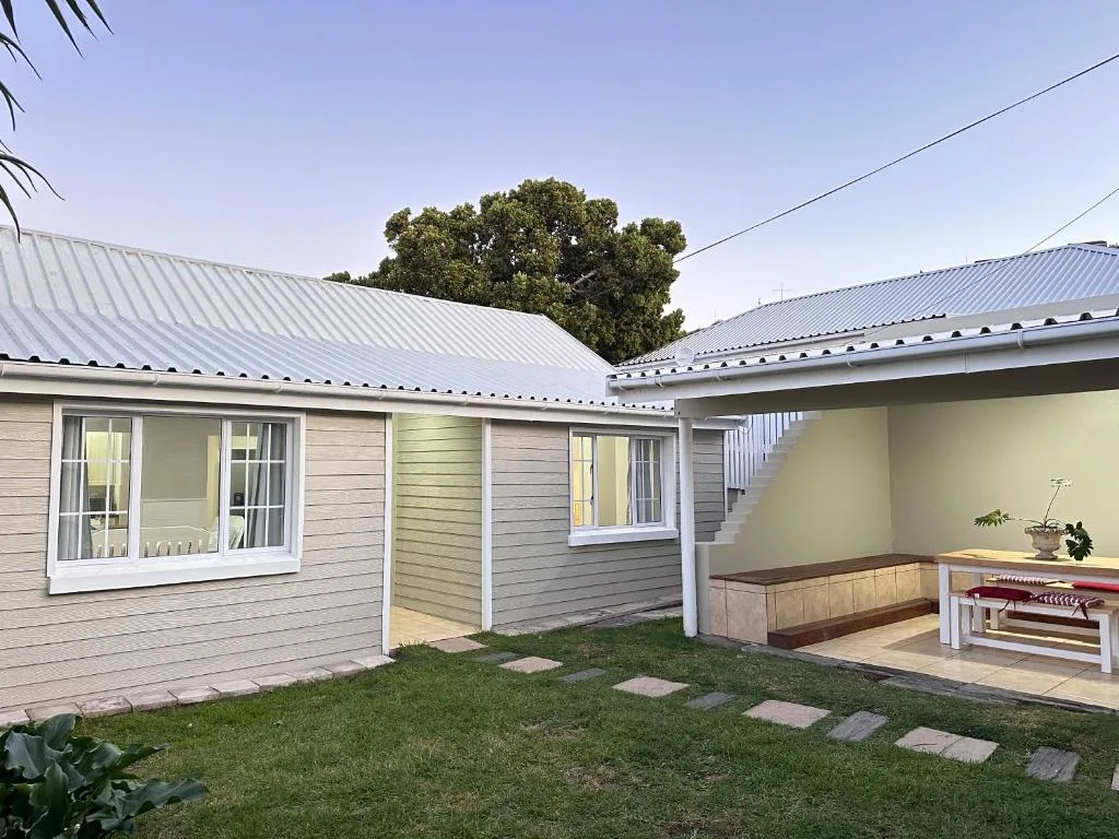 Modern villa with corrugated metal roof and manicured garden courtyard