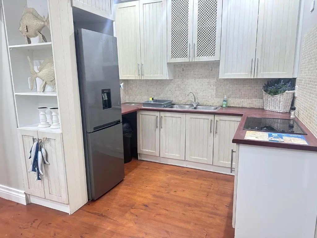 Modern kitchen with white cabinetry, stainless steel appliances, and tiled backsplash