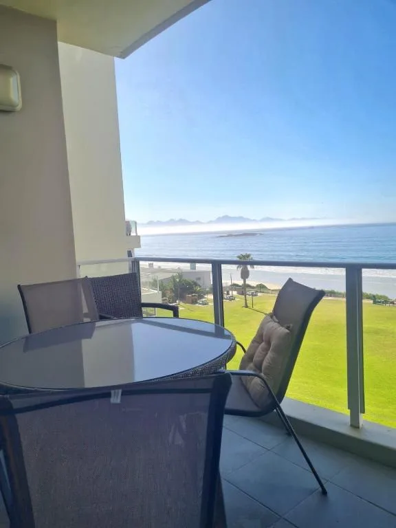 Seaside balcony with seating overlooking beach, ocean and mountains