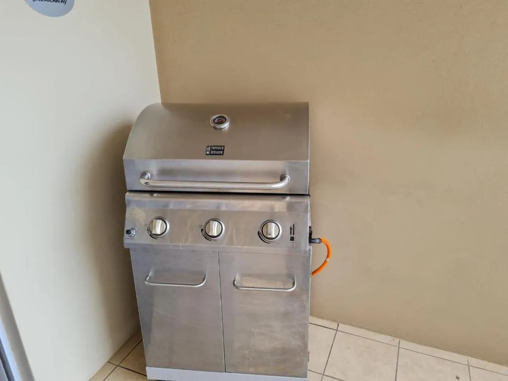 Stainless steel gas braai grill with three burners and storage compartment