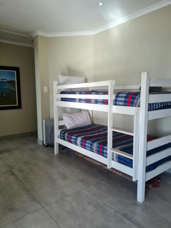 Bright bedroom with white bunk beds and patterned blue bedding