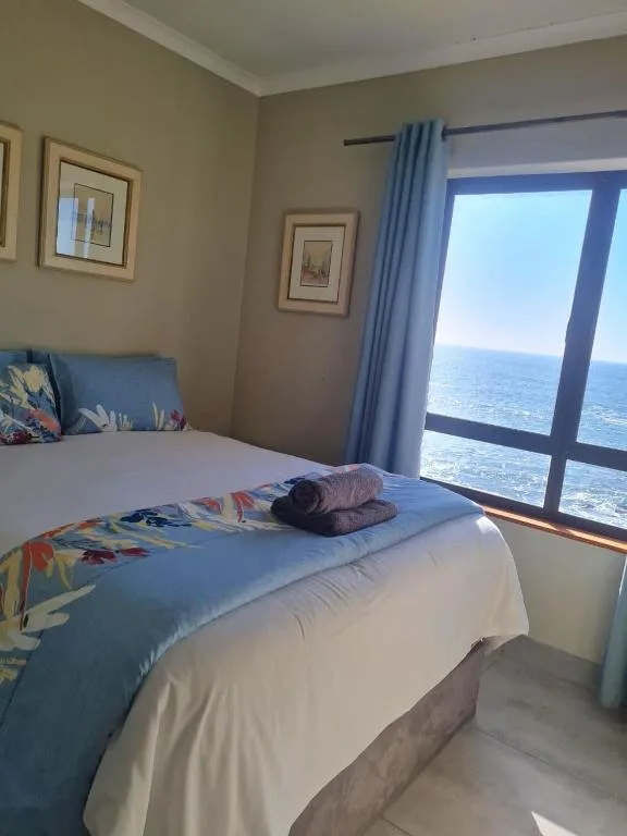 Bright bedroom with ocean view through large sliding glass door
