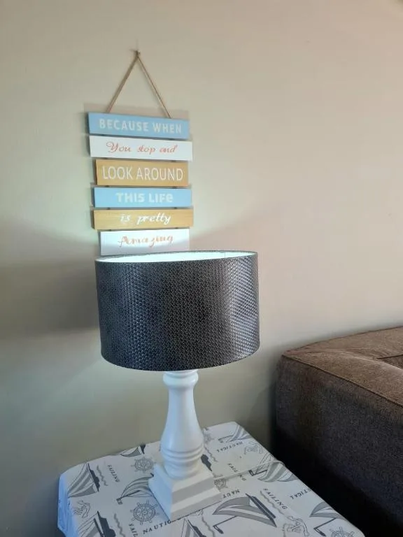 Decorative table lamp with inspirational wooden sign hanging above it