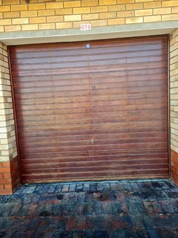 Wooden garage door with brick surround and brick driveway entrance