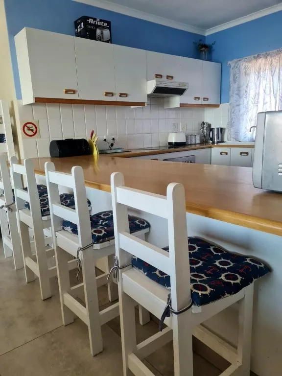 Modern kitchen with white cabinetry, dining table, and stainless steel appliances