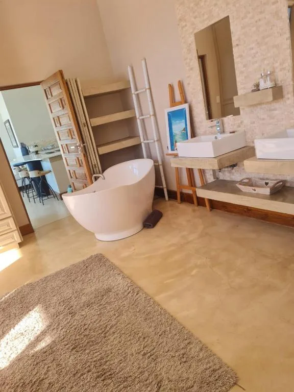 Modern bathroom with freestanding white tub and wooden vanity countertop
