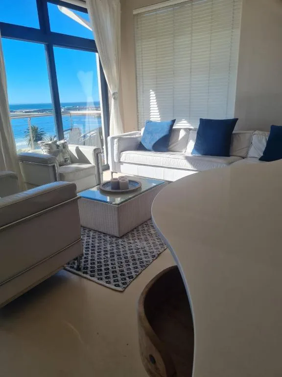 Bright lounge with coastal ocean view through large windows and blue cushioned seating
